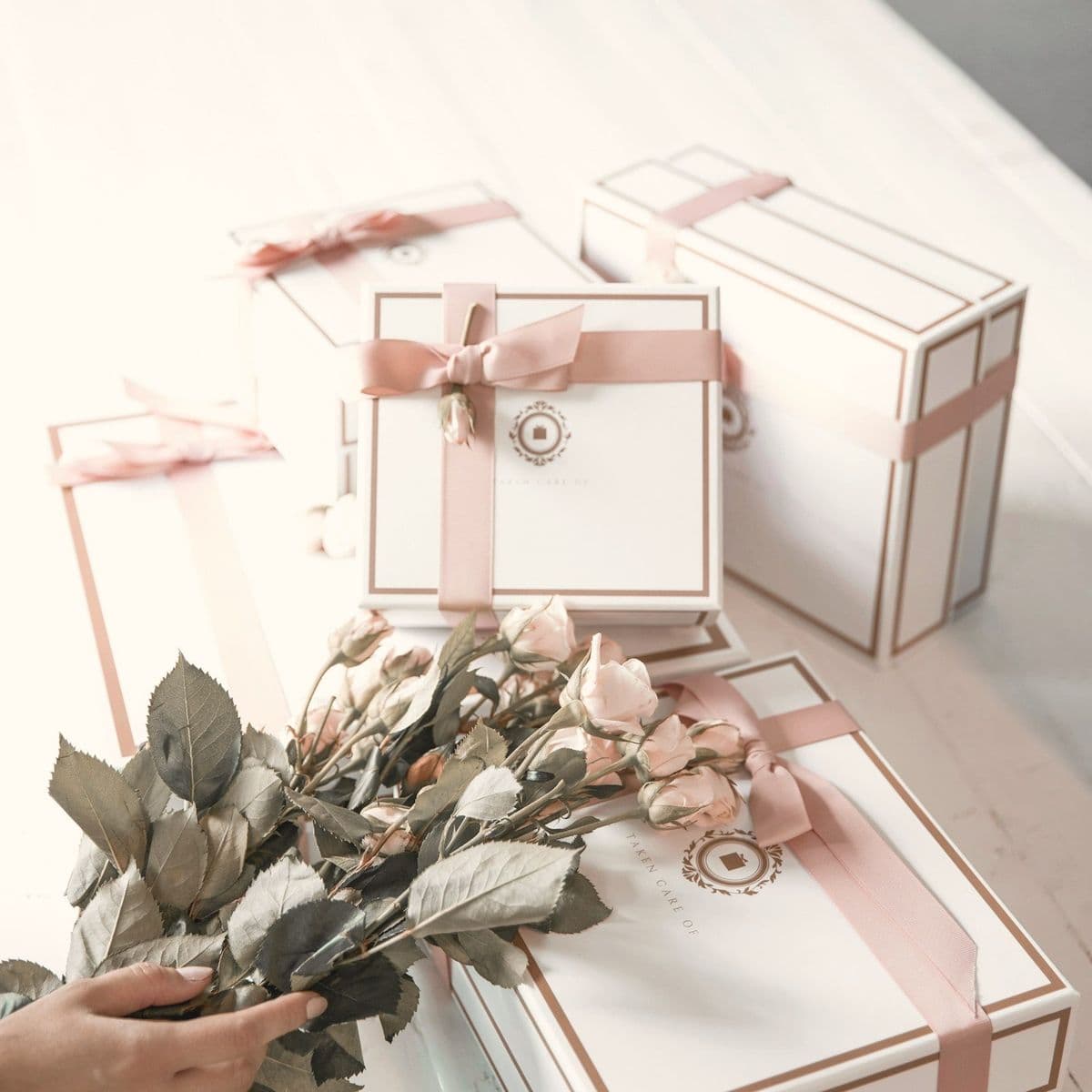 Gift boxes tied with pink ribbon and dried roses