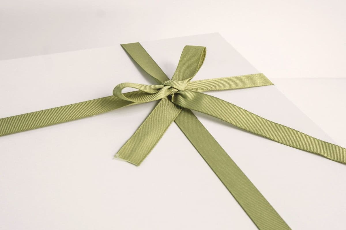 A pistachio green satin ribbon tied in a bow
